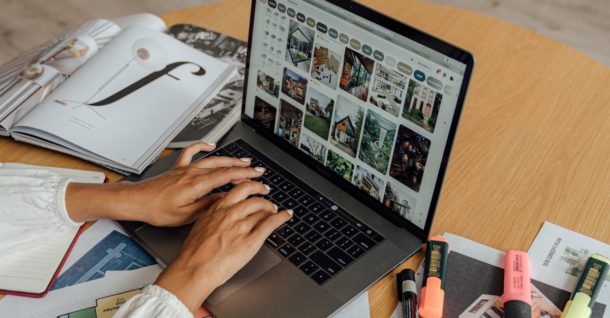 A person working from home with a laptop, coffee, and magazines on a wooden table, showcasing a freelancing lifestyle.